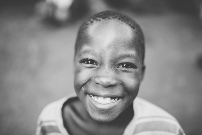 black and white photo of child smiling at camera